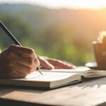 Persona escribiendo un relato de escritura de ficción en un cuaderno.